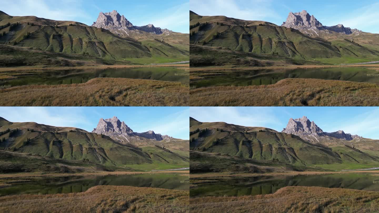 放大拍摄草原，画面中间有高山峰顶和水坑
