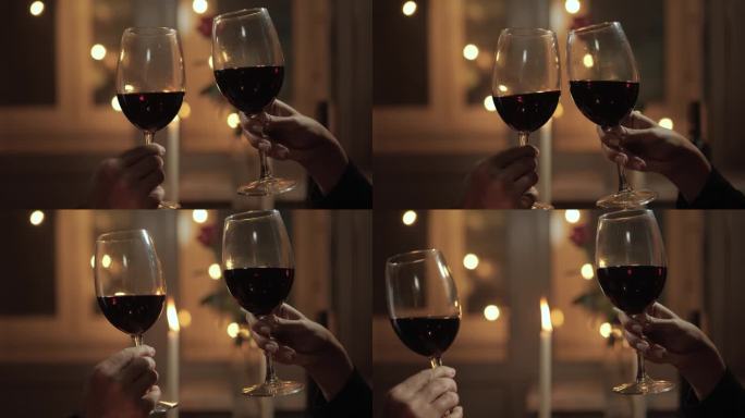 约会，情人节，纪念日，浪漫的晚餐。在烛光和浪漫的夜晚气氛的衬托下，两只玻璃杯叮当作响
