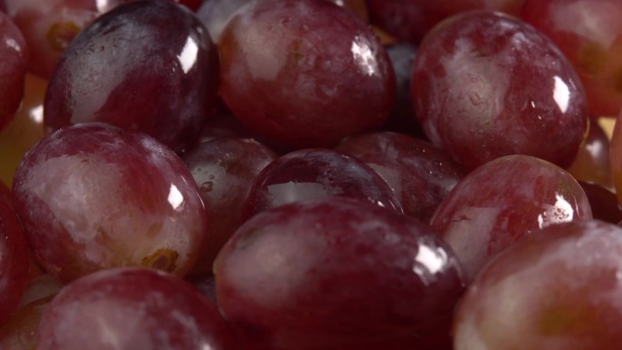 新鲜的一串串红色或粉红色的葡萄作为背景旋转。葡萄特写，概念酿酒，葡萄酒生产，葡萄品种