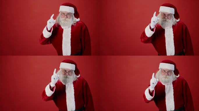 皱着眉头的圣诞老人摇着手指，纯红色背景