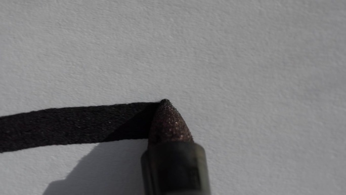 用黑色记号笔在一张白纸上画一条直线的微距特写镜头