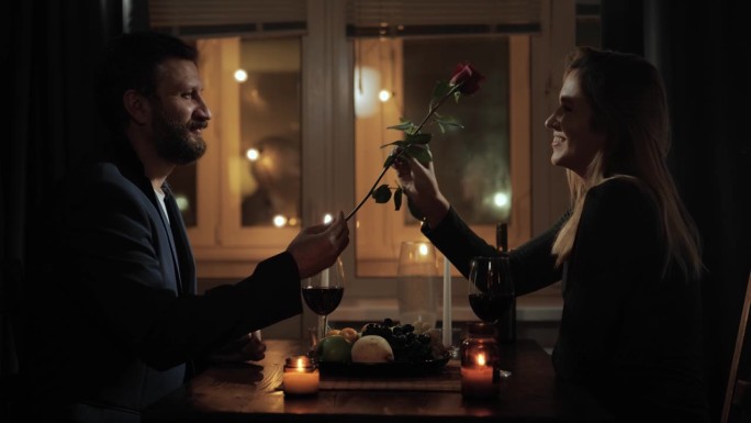 约会，情人节，第一次约会。不管是在饭店还是在家里，浪漫的烛光晚餐中，男人都会送给女人一朵玫瑰