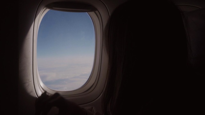 女游客在日本旅行时打开飞机窗户