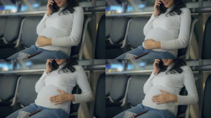 愉快的孕妇坐在沙发上等待，与家人在机场打电话