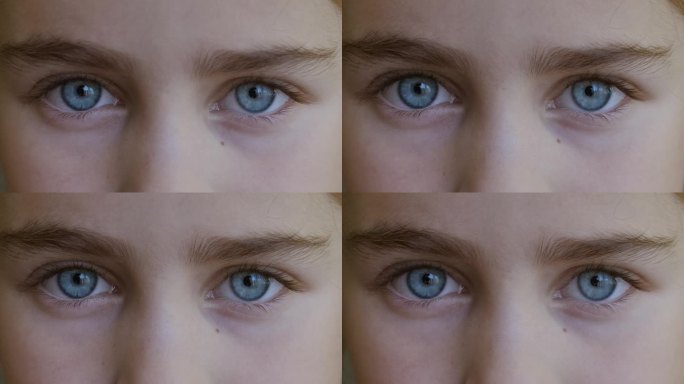 孩子的蓝眼睛看着镜头特写。微距镜头打开和关闭蓝眼睛小女孩。儿童眼睛的近距离运动。人眼虹膜张开瞳孔。