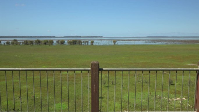 从椭圆形窗户内部向后推，向后移动，引入大型湖泊和湿地观景台的框架。