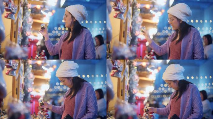 一名怀孕的亚洲年轻女子在圣诞市场为她的朋友挑选圣诞礼物。