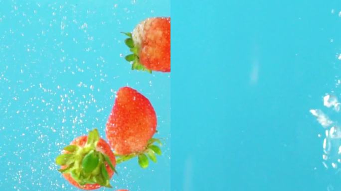 水中落入新鲜的草莓和蓝莓