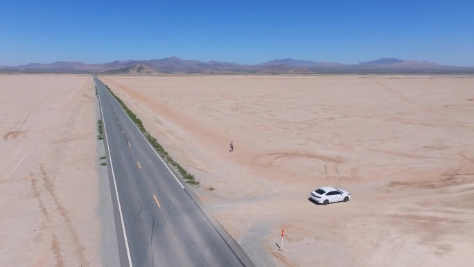穿过沙漠山谷通向地平线的无尽道路。沙漠的鸟瞰图。