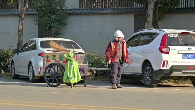 一名环卫工人，路边清扫垃圾，捡垃圾