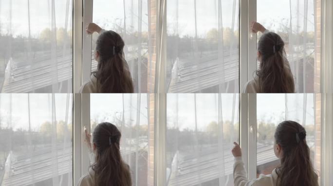 一个女人关上了一扇微掩的PVC塑料窗，拉上了窗帘。