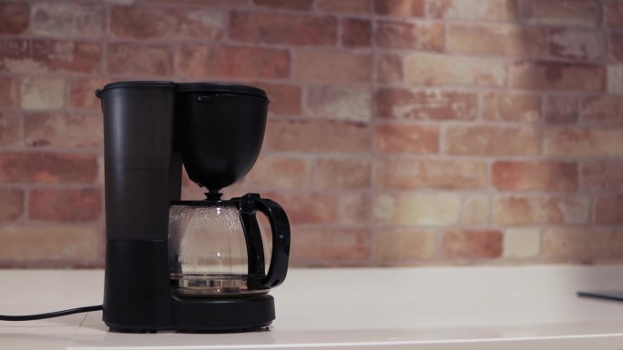 靠近砖墙的厨房桌子上的咖啡机特写，厨房里的咖啡机正在煮咖啡。高品质4k画面