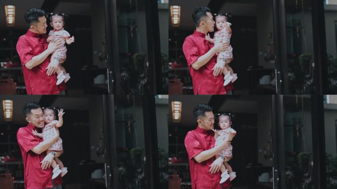 中国新年骄傲的父亲抱着女儿在房子前团聚
