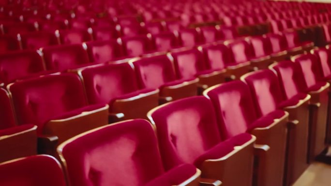主观的观众在空无一人的音乐厅里，拿着空无一人的红色天鹅绒扶手椅