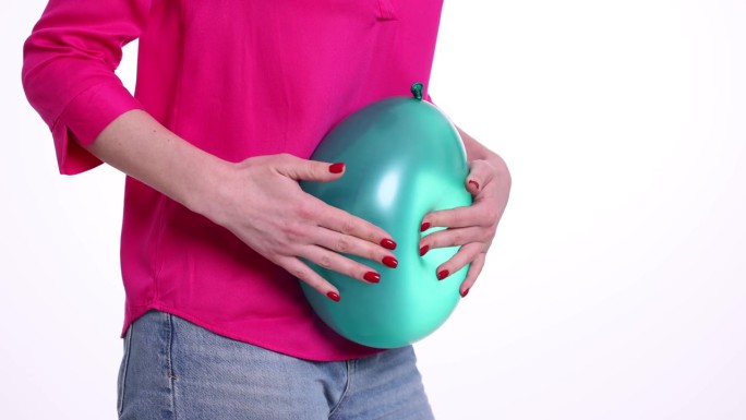 女人拿着气球，感觉肚子胀胀的
