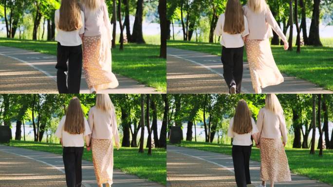 女孩和妈妈在夏日公园里放松地散步