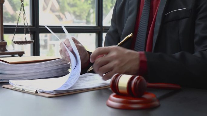 律师阅读合同文件中的条款、法律协议并签字