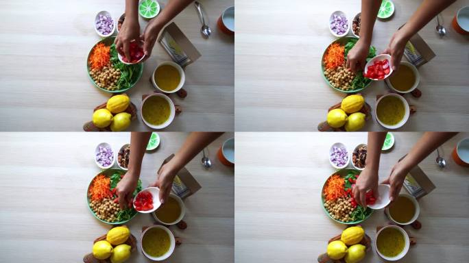 俯视图拍摄制作沙拉，加入番茄胡萝卜菠菜鹰嘴豆柠檬洋葱坚果酱