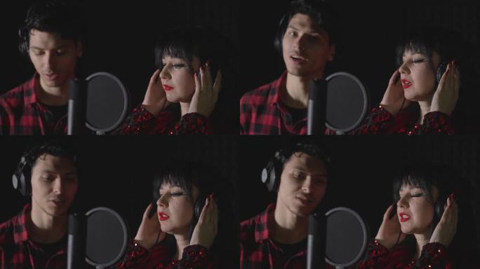 一个男人和一个女人，有抱负的艺术家，站在录音棚里唱一首歌。正在录制中。