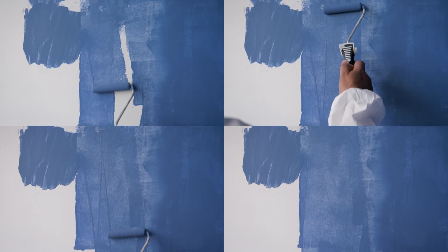 油漆工用蓝漆粉刷白墙的特写
