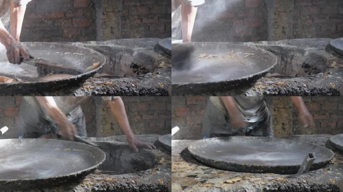 一个工人在工厂里清洗和安装一个生锈的用于生产豆浆的金属锅的特写。