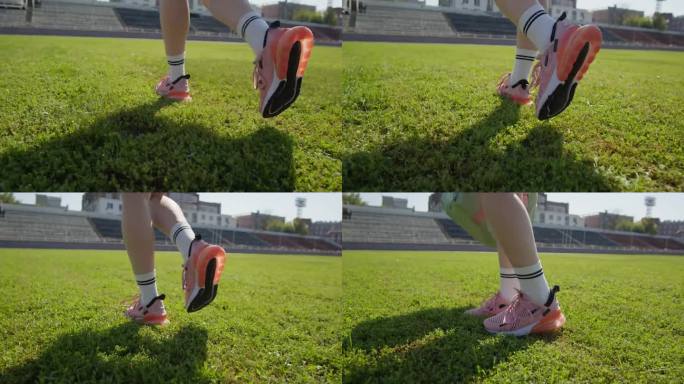 女子穿着白袜子和粉色运动鞋走在绿色的草地上。年轻女子把她的运动包和垫子放在体育馆的草坪上。腿部特写