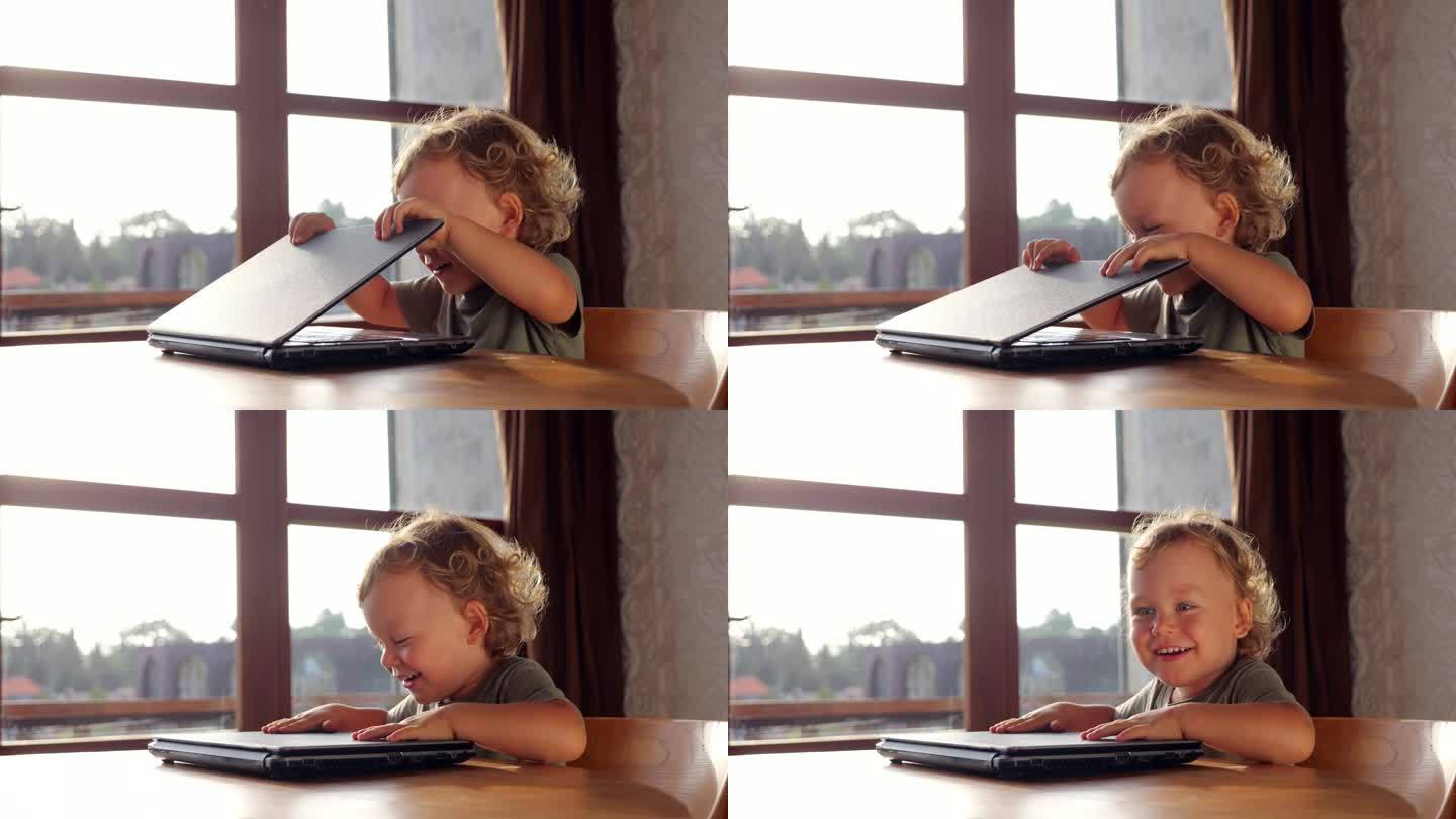 小男孩笑着合上笔记本电脑的盖子，直视镜头
