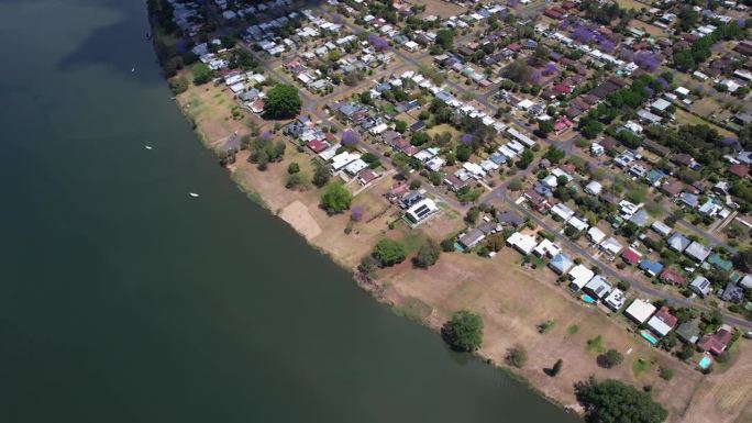 江边住宅村里的紫色蓝花楹树。克拉伦斯河位于澳大利亚新南威尔士州格拉夫顿。空中拍摄