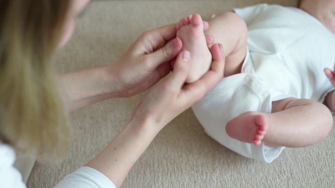 妈妈给宝宝按摩脚。产假概念，护理，婴儿按摩。预防扁平足。肌张力去除