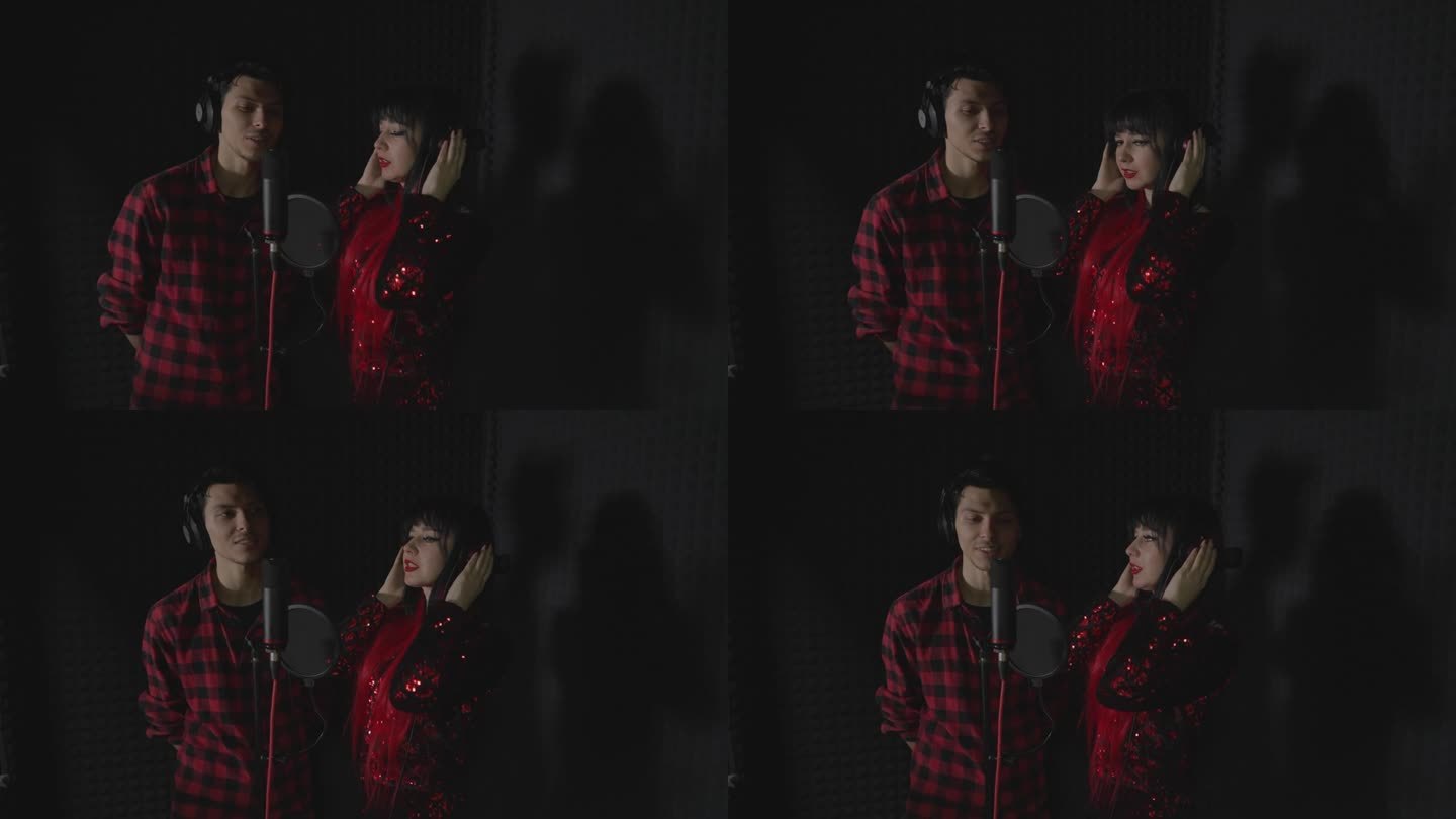 一个男人和一个女人，有抱负的艺术家，站在录音棚里唱一首歌。正在录制中。