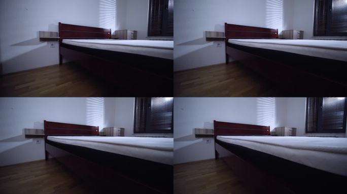 现代公寓的卧室。床的壁橱和窗帘的影子在墙上。右镜头移动。