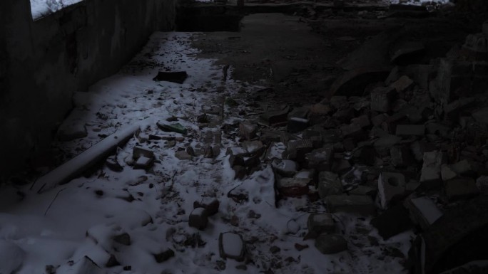 废弃建筑的地板上有雪和碎砖