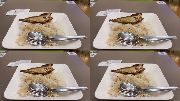 餐馆的桌子上有煮米饭和鱼。