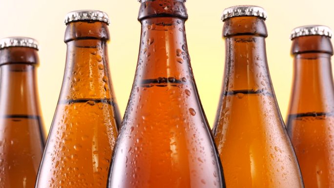 啤酒瓶的特写。棕色的玻璃瓶装满了金色的啤酒，体现了酒精饮料的本质，夏季的茶点，以及啤酒节的精神