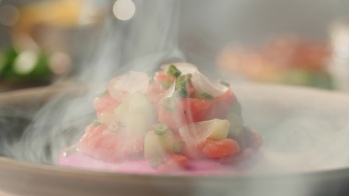 智利三文鱼塔塔服务，牛油果和黄瓜在紫色奶油奶酪与绿色洋葱在雾中旋转，洋葱健康饮食食品，近红鱼塔塔。