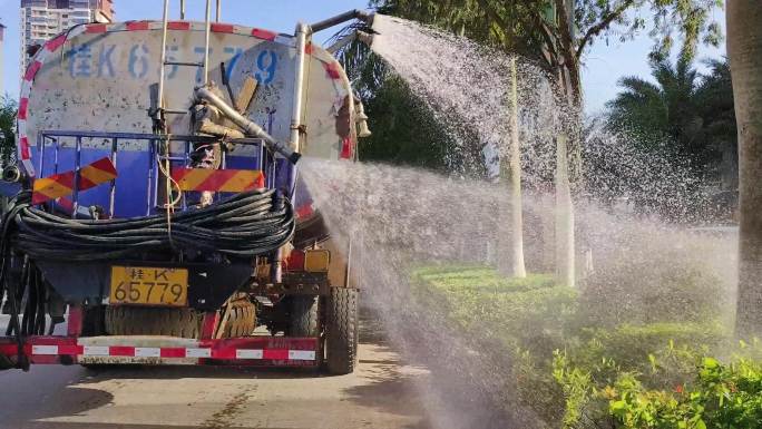 环卫洒水车实拍洒水特写城市绿化带洒水