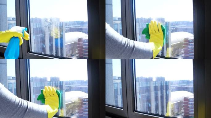 人，家务和持家观念——女人戴着手套，用抹布和清洁剂在家里喷擦窗户