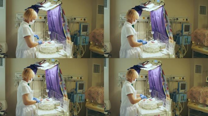 戴着防护口罩在医院工作的女护士。新生儿复苏。女医生站在育婴箱里的新生儿旁边。早产儿保健和医疗理念。