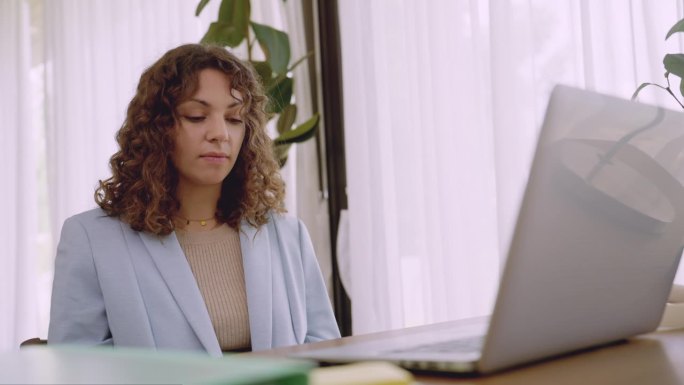心情不好的年轻白人女性在现代办公室里用笔记本电脑进行在线会议，讨论公司业务中的严重错误，绝望的女员工