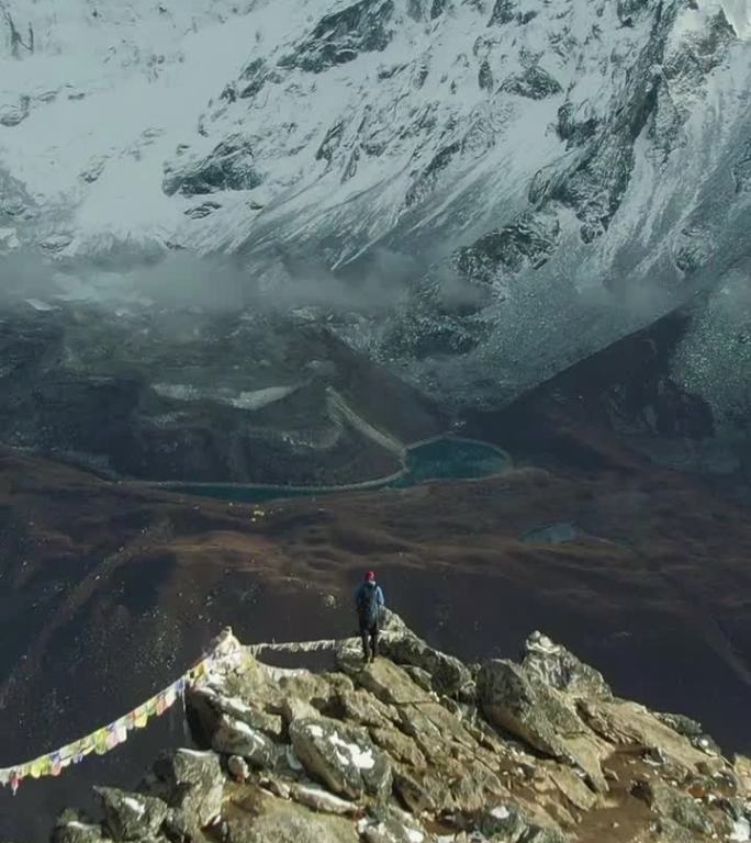 南嘎曾山和阿玛达布兰山山顶上的徒步旅行者。尼泊尔。鸟瞰图。垂直视频