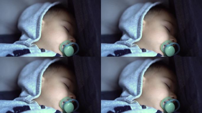 一个小男孩睡在婴儿车里(特写)。拿着奶嘴的孩子。4 k