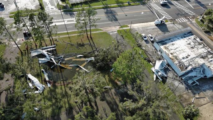 飓风过后的街道和商店成了废墟:北佛罗里达州佩里小镇扭曲的屋顶和倒下的树木。航空镜头与静态相机运动