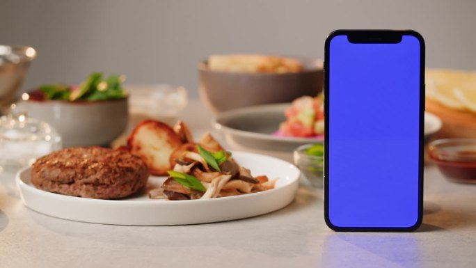 花式餐厅订桌应用，手机送餐应用配色度键绿屏，餐点焦油焦油鸡和炸鸡薯条，上木桌准备外卖。