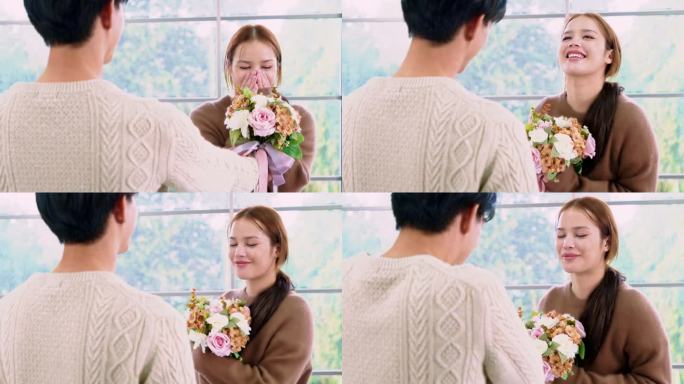 一名年轻的亚洲男子给女友一个惊喜，在她的周年纪念日回家时送给她一束玫瑰和鲜花。亚洲女人喜欢收到男友送
