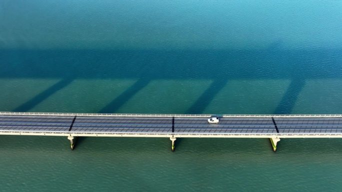 蓝绿色海水上的桥梁，城市基础设施，汽车道路抽象对称