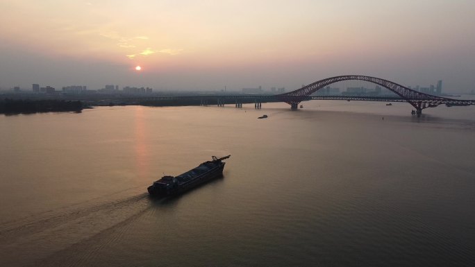 航拍黄昏落日下江面行驶的船明珠湾大桥日落