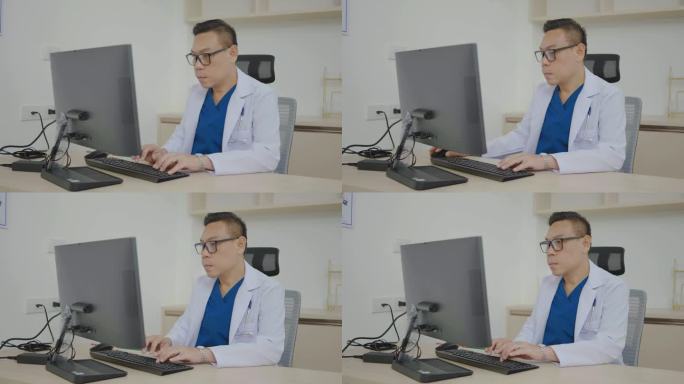 医院医生办公室:亚洲专业男性医生在台式电脑上工作、在线诊疗、网络视频电话会诊、写数字处方的画像