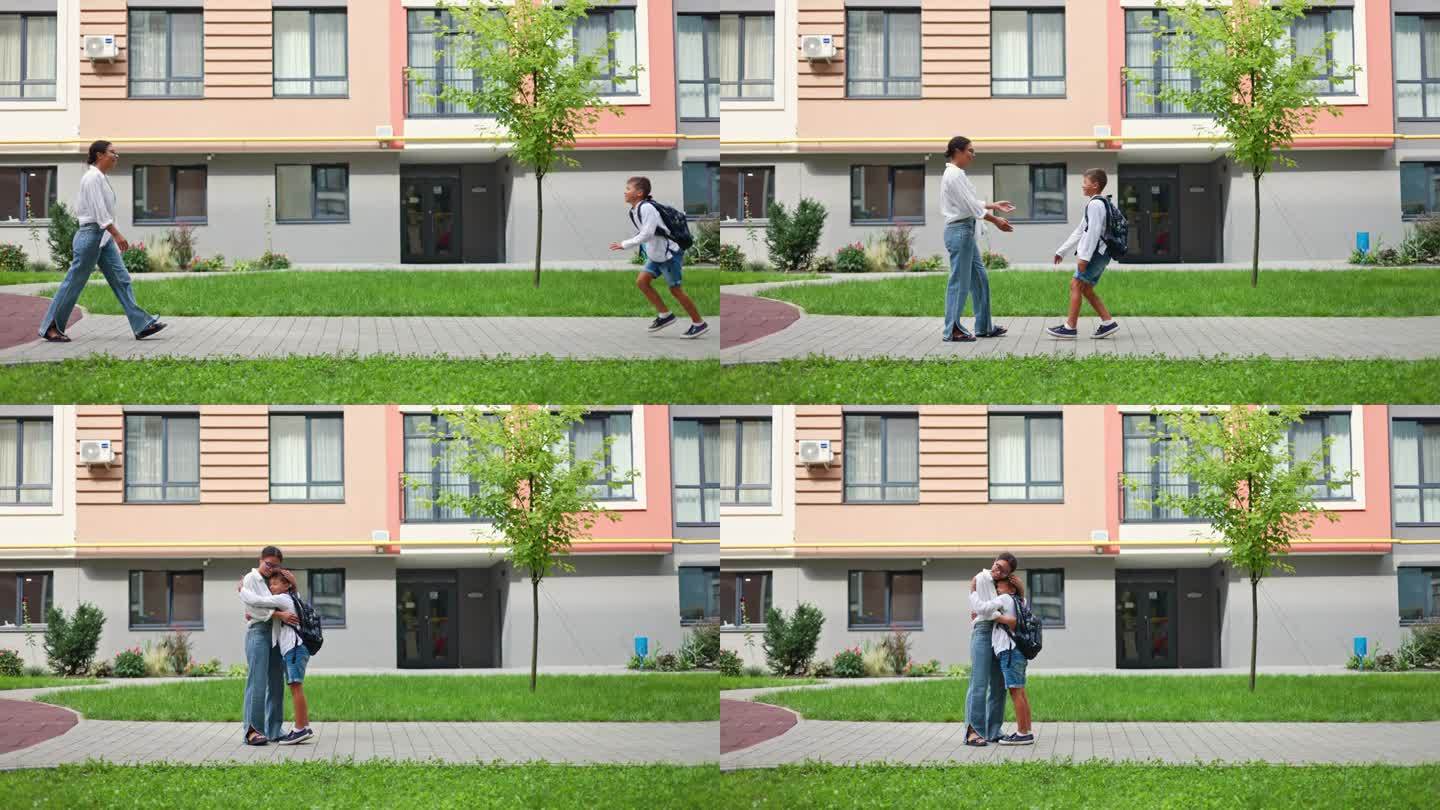 一位非裔美国母亲站在学校大楼外，在一天的学习结束后，温暖地拥抱着她的儿子。在学校度过了漫长的一天后，