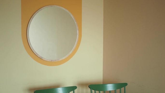 一面圆形的镜子挂在墙上。