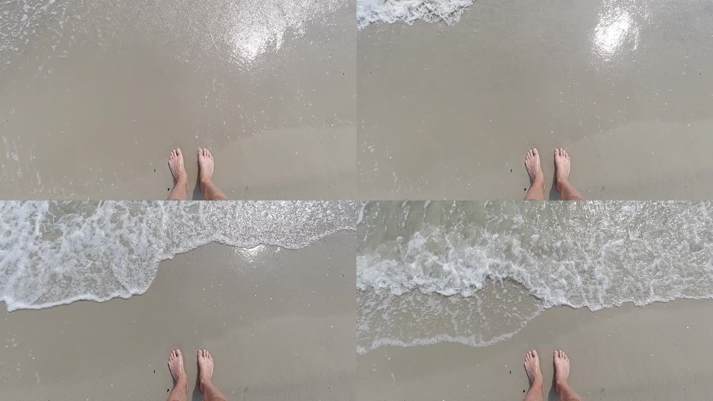 海边男人的腿。海浪涌上来，碰着一个人的脚。缓慢的运动。